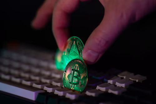 Bitcoin- und Ethereum-Münzen über einer Tastatur bei schwachem Licht